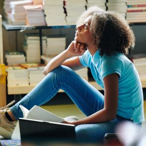 Girl thinking with books aroun dher
